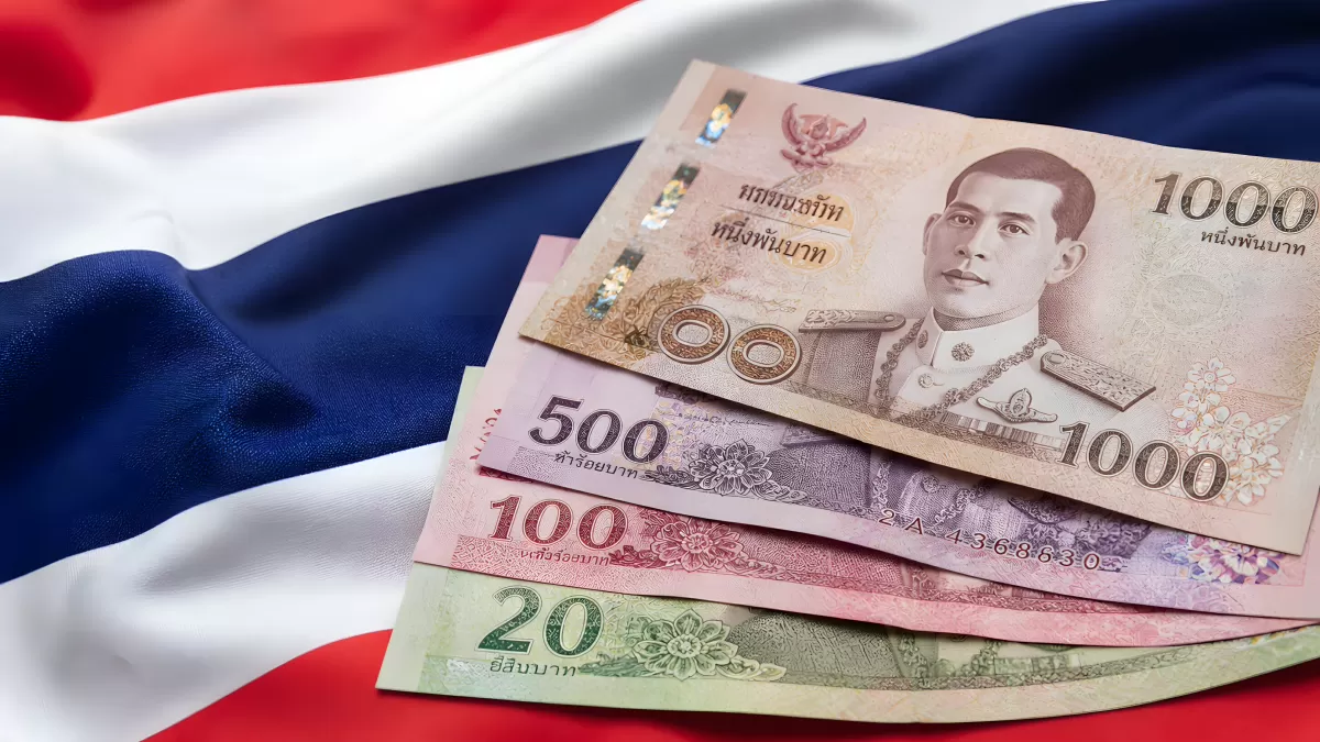 Thailändische Baht-Scheine vor der Nationalflagge