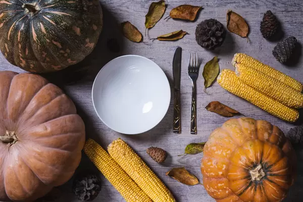 Thanksgiving background with freshly harvested pumpkins and corns