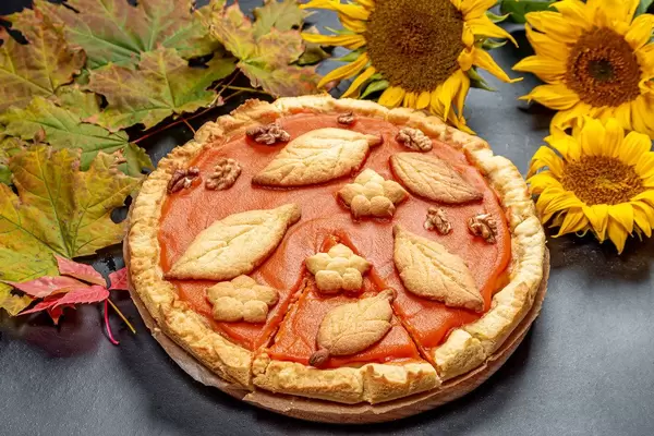 Thanksgiving pumpkin pie on a table with autumn leaves (Flip 2019)