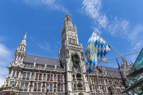 The Bavarian flag in front of rainbow flags at Marienplatz for Munich Pride, to set an example for more tolerance towards the gay community