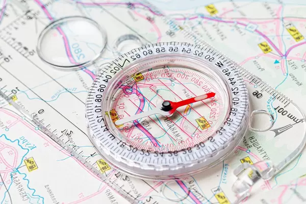 The compass lies on the map. Terrain orientation concept (Flip 2020)