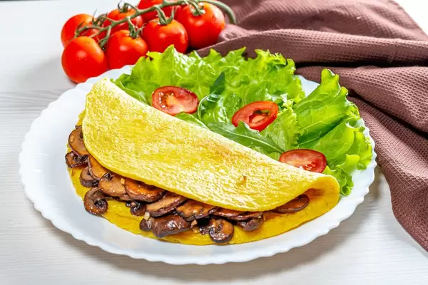 The concept of Breakfast. Egg omelet with mushrooms and vegetables (Flip 2019)