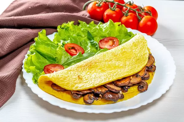 The concept of Breakfast. Egg omelet with mushrooms and vegetables