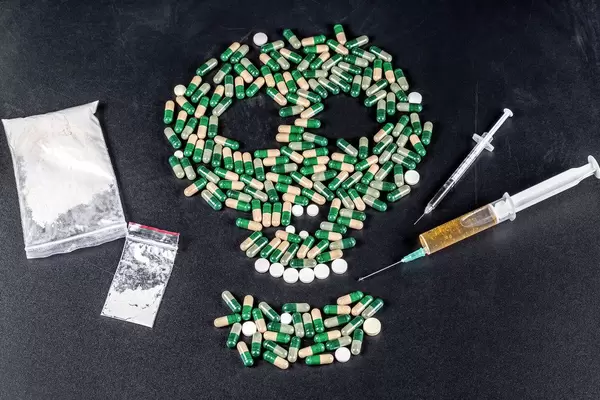 The concept of deadly danger and addiction-a skull and drugs on a black background