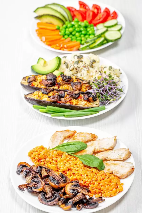 The concept of delicious healthy food. Baked eggplant with couscous, chicken with mushrooms and chickpeas and vegetable slicing (Flip 2019)