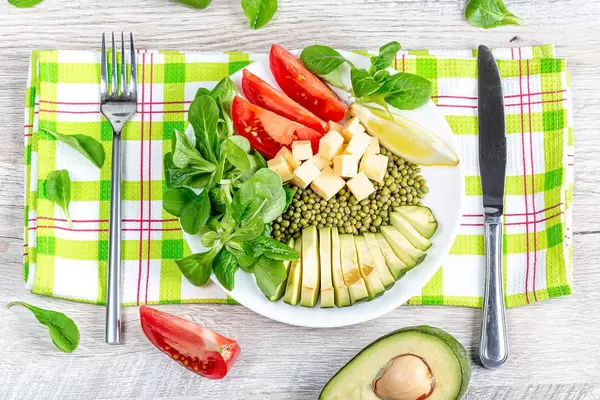 The concept of healthy and proper nutrition. Mung with cheese, vegetables and herbs, top view