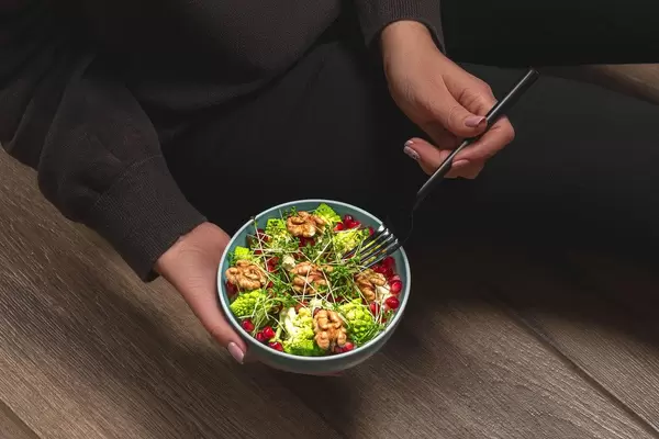 The concept of proper nutrition. A woman with a diet salad in her hands (Flip 2020)