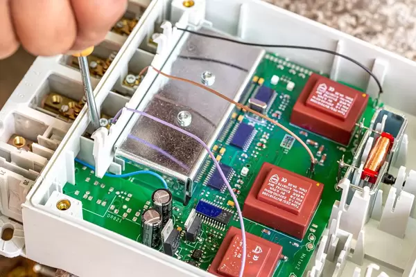 The concept of repairing electronic devices. Worker with a screwdriver in the process of troubleshooting