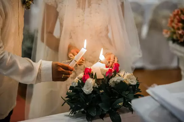 The couple lighting a unity candle at a wedding