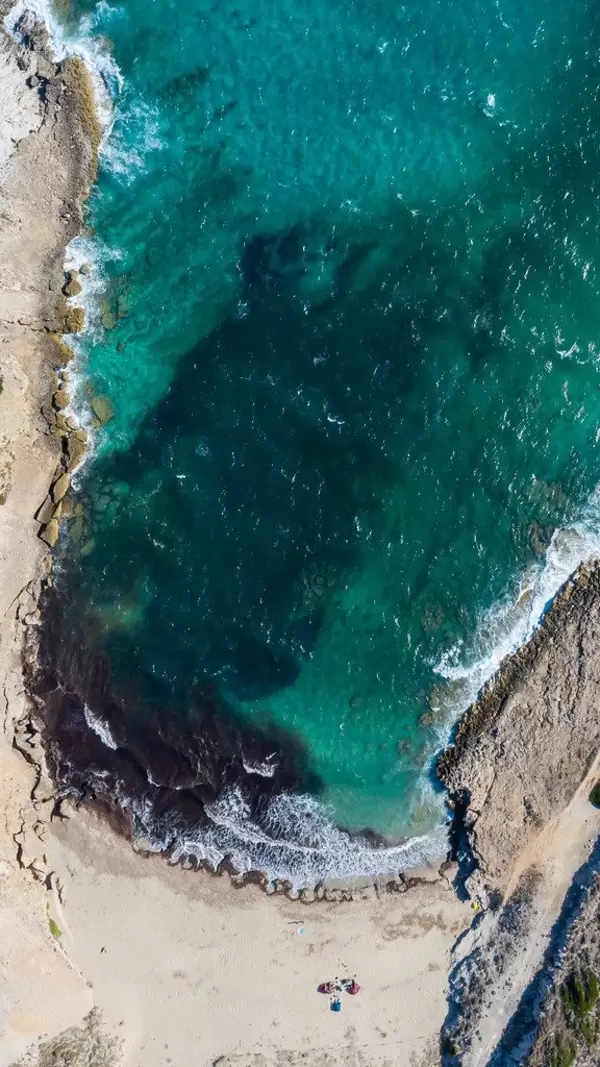 The cove of Cala Mitjana on Mallorca seen from above. Sandy beach with crystal clear waters