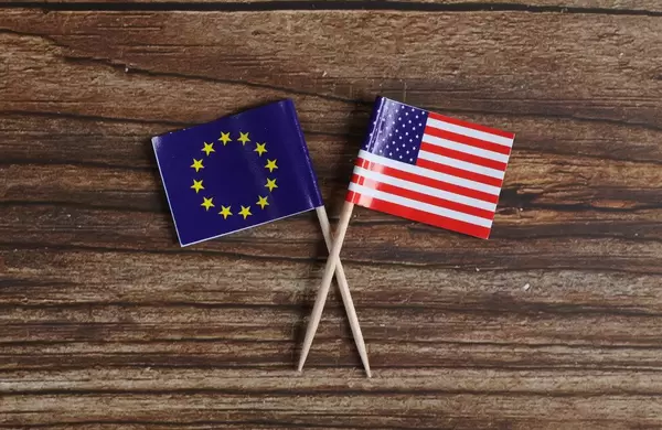 The European flag and American flag on wooden table