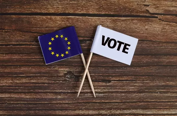 The European flag and white flag with vote text on wooden table