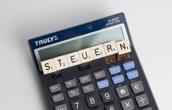 The German word 'Steuern' shot from above with digital calculator lying underneath