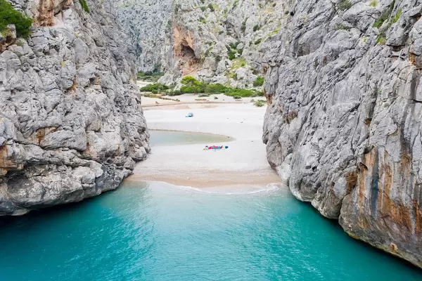 The hidden beach of Sa Calobra: turquoise waters between steep cliffs. Drone photo in Mallorca