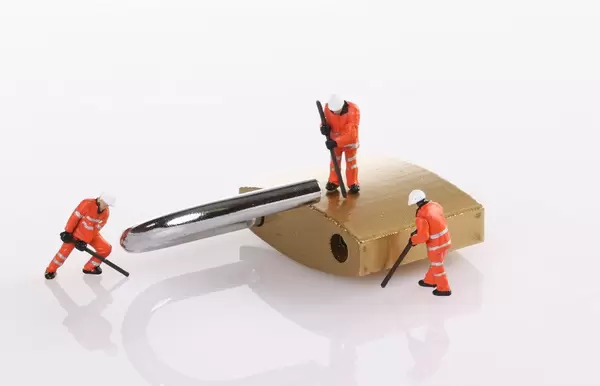 The images are miniature people try to unlock metal padlock