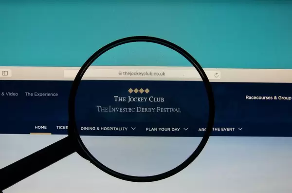 The Jockey Club logo on a computer screen with a magnifying glass