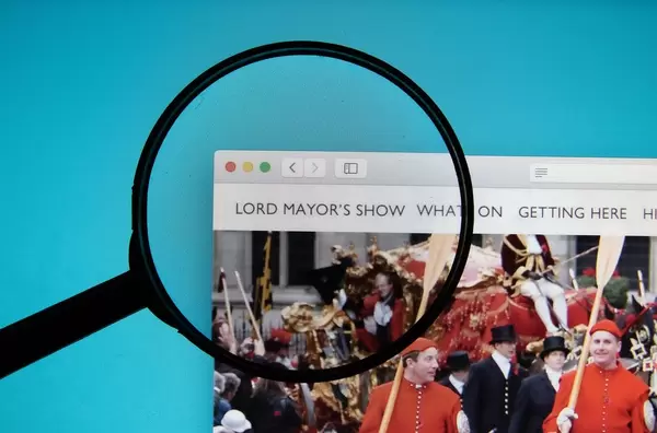 The Lord Mayor's Show website on a computer screen with a magnifying glass