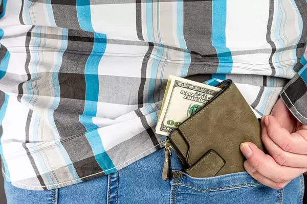 The man puts a wallet with money in his pocket (Flip 2020)