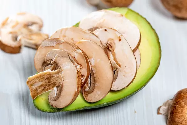 The mushroom pieces fresh avocado - preparing to bake
