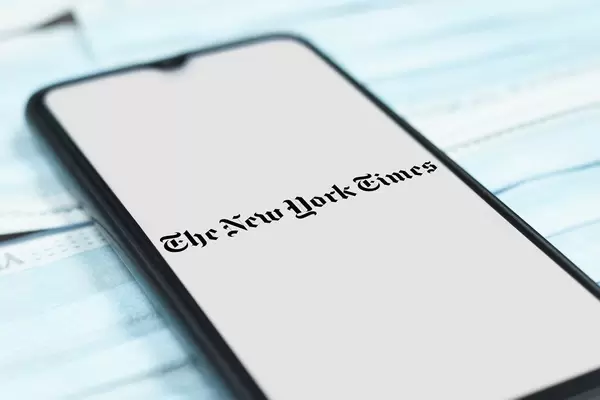 The New York Times -  American newspaper logo on smartphone screen over the face masks