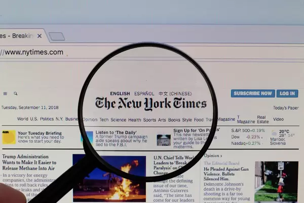 The New York Times Logo am PC-Monitor, durch eine Lupe fotografiert