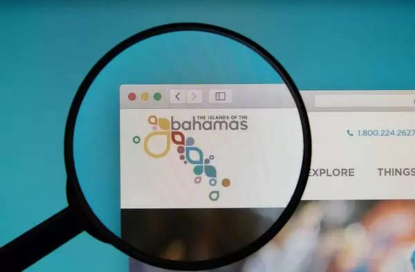 The Official Site of The Bahamas on a computer screen with a magnifying glass