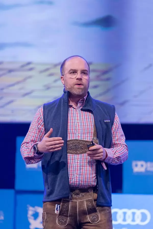 The Pitch Doctor - Cristoph Sollich in traditional bavarian leatherpants on the stage as a speaker at the Bits & Pretzels Festival in Munich
