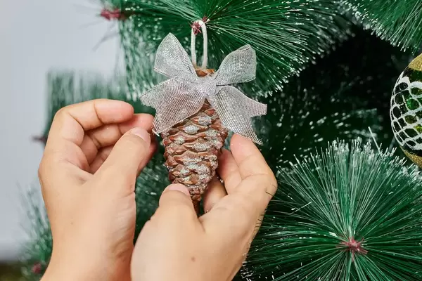 The preparation process for celebrating New Year or Xmas. Decorating a festive tree with toys