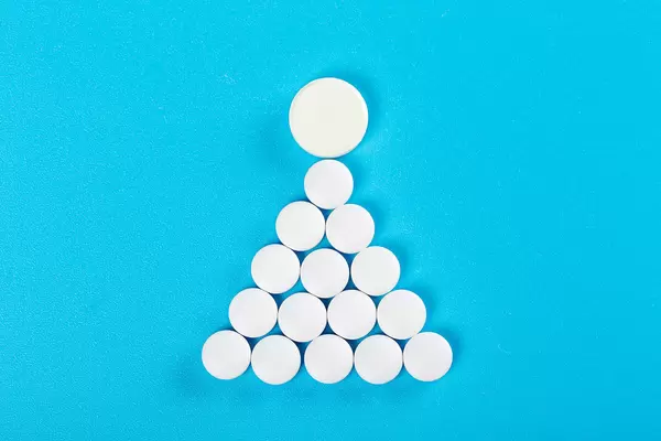The sign or symbol of a woman is made of white tablets on a blue background