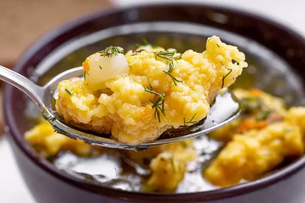 The spoon with the dumpling and soup closeup