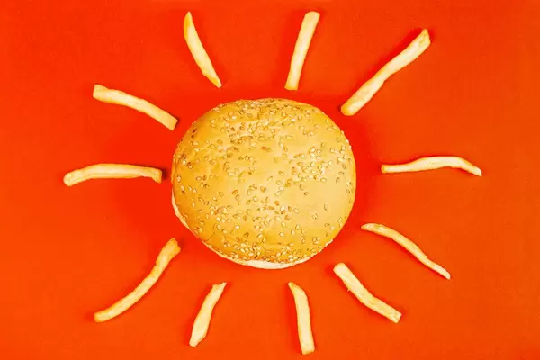 The sun is made from a Burger and fries on a red background