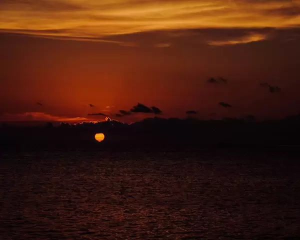 The sun setting behind the clouds