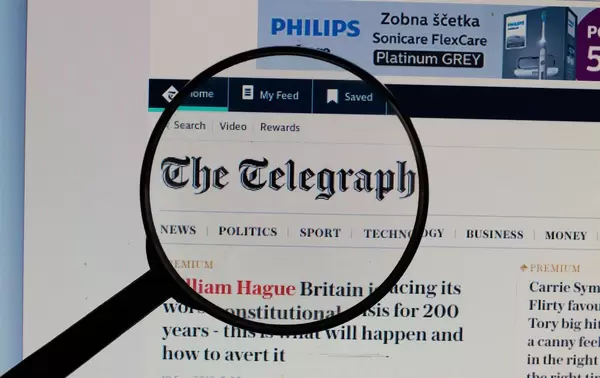 The Telegraph Logo am PC-Monitor, durch eine Lupe fotografiert