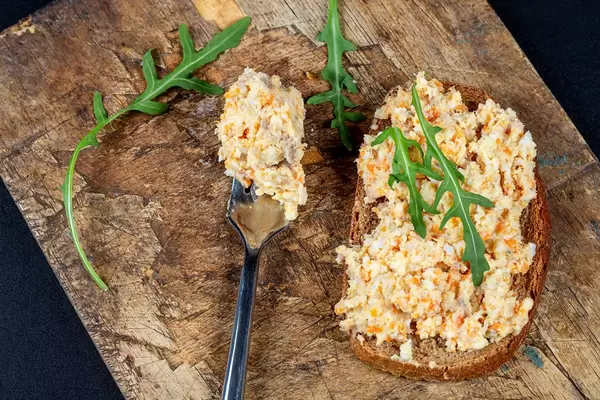 The view from the top, a sandwich with black bread, pate and rocket leaves on old wooden kitchen Board (Flip 2020)