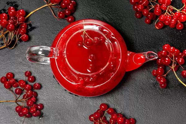 The view from the top glass kettle with fresh berries of viburnum on a black background (Flip 2019)