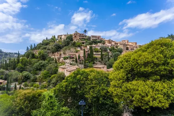 The village of Deià, Majorca, Balearic islands. Houses on a hill among trees with blue sky