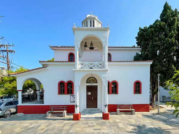 The white and red church of Agia Triada with central bell tower in Skiathos town, Greece