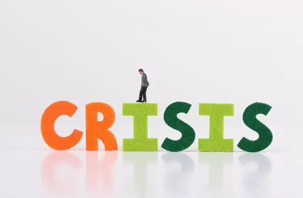 The word Crisis with businessman on white background