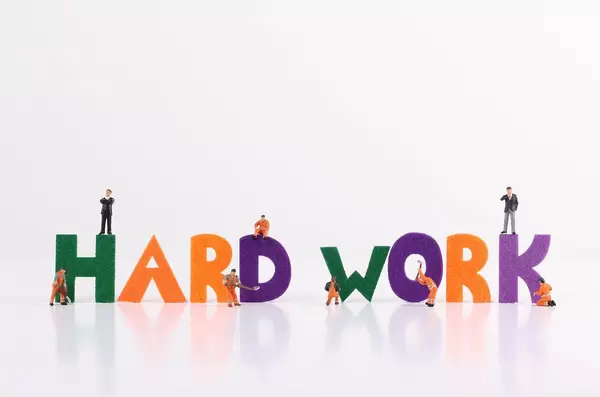 The word Hard Work with tiny workers on white background