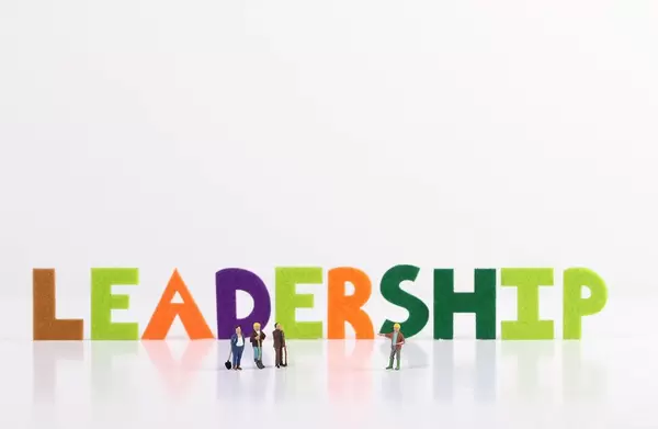 The word Leadership with construction workers on white background