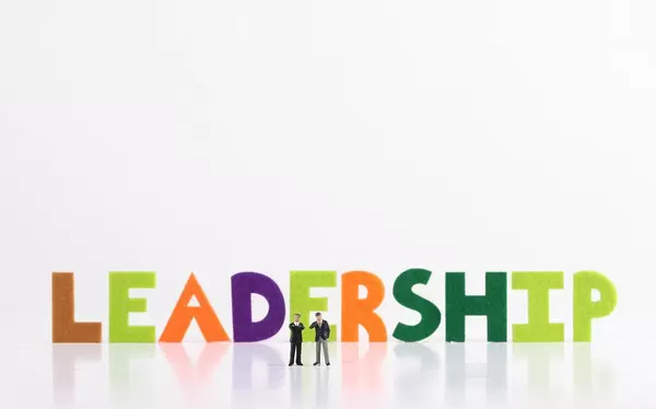 The word Leadership with two businessman on white background