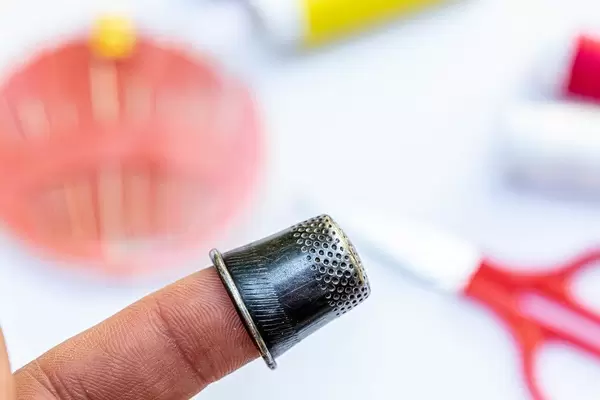 Thimble on finger close-up