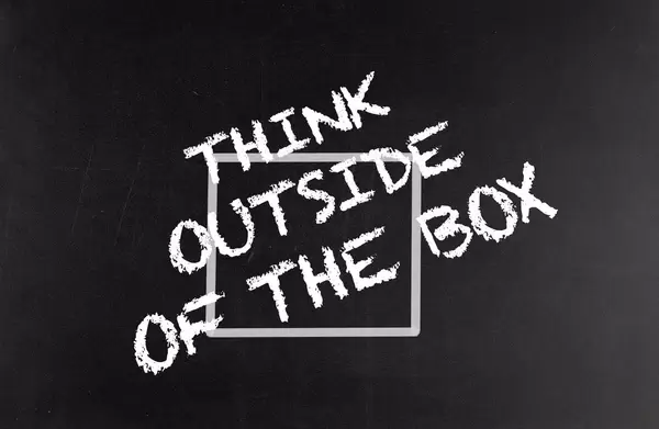 Think outside of the box text on blackboard