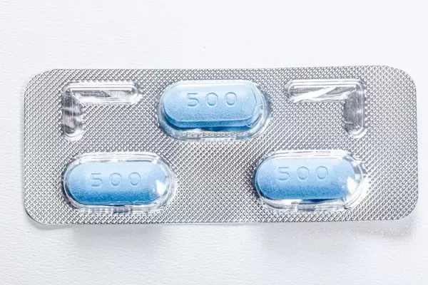 Three blue antibiotic pills in a pack. View from above