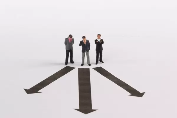 Three businessman in front of decision which way to choose