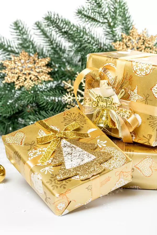 Three christmas gifts with branches of a christmas tree