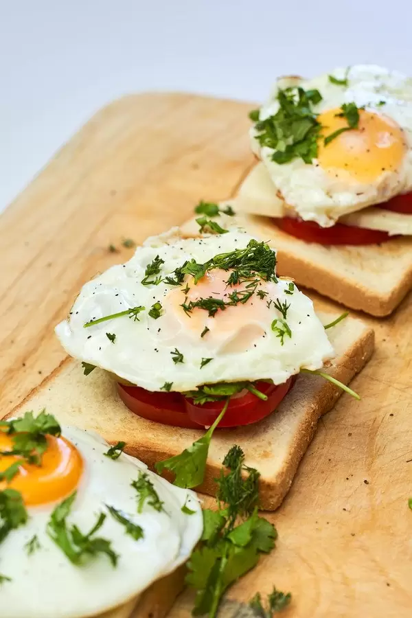 Three delicious fried eggs on toast for breakfast