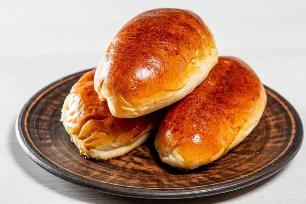 Three fresh baked pies on a brown plate