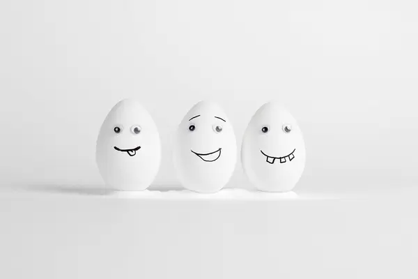 Three happy eggs with eyes and cheeky faces