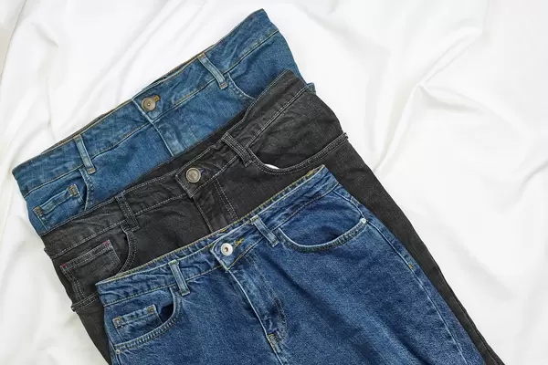 Three jeans trousers on white